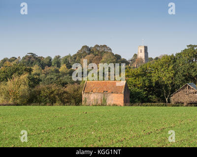 Traditional English rural landscape with brick farm building and church ...