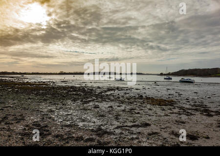 Low winter light casts a dreary light across Chichester Harbour, seen from the beach at Dell Quay, West Sussex, UK Stock Photo