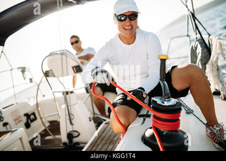 Attractive strong woman sailing with her boat Stock Photo