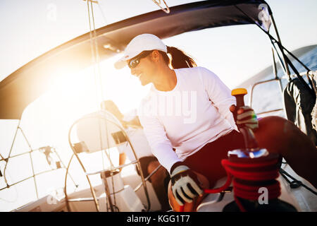 Attractive strong woman sailing with her boat Stock Photo