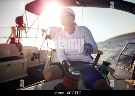 Attractive strong woman sailing with her boat Stock Photo