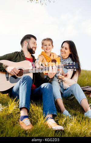 man playing guitar with family Stock Photo