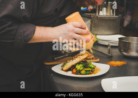 A chef prepares food in the kitchen of a restaurant