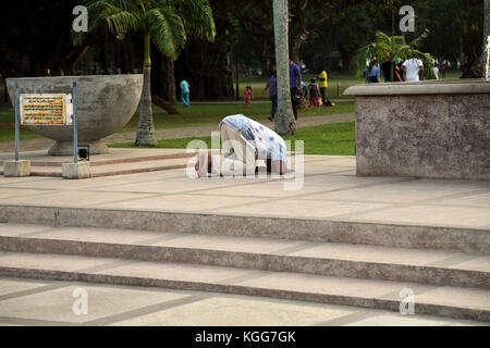 Viharamahadevi Park Hunupitiva Colombo Sri Lanka man worshipping in front of large gilded Buddha Stock Photo