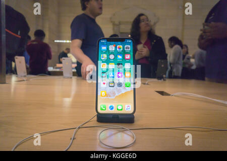 Customers in the Apple store in Grand Central Terminal in New York try out the new iPhone X on Friday, November 3, 2017, the first day it went on sale.  The new phone, anxiously awaited by drooling iPhone aficionados, sells for a whopping $999 and features an all-new 5.8-inch super retina display with OLED screen in addition to its facial-recognition technology.  (© Richard B. Levine) Stock Photo