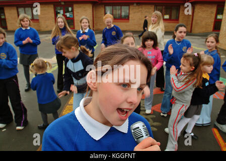 Penyrheol Primary School, Gorseinon, Swansea. Zoe Owens leads the routine with the karaeoke microphone for the lunchtime dance club. Stock Photo