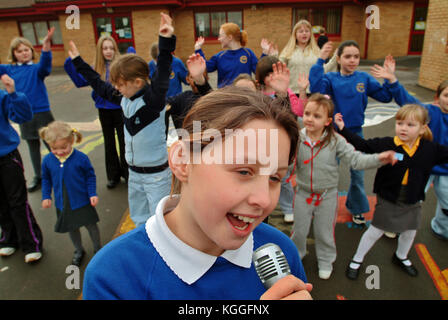 Penyrheol Primary School, Gorseinon, Swansea. Zoe Owens leads the routine with the karaeoke microphone for the lunchtime dance club. Stock Photo