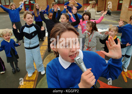 Penyrheol Primary School, Gorseinon, Swansea. Zoe Owens leads the routine with the karaeoke microphone for the lunchtime dance club. Stock Photo