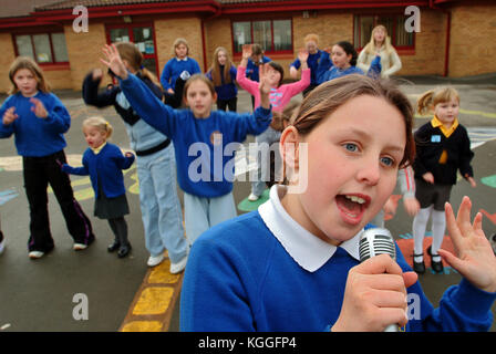 Penyrheol Primary School, Gorseinon, Swansea. Zoe Owens leads the routine with the karaeoke microphone for the lunchtime dance club. Stock Photo