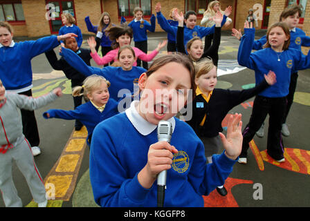 Penyrheol Primary School, Gorseinon, Swansea. Zoe Owens leads the routine with the karaeoke microphone for the lunchtime dance club. Stock Photo