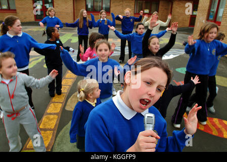 Penyrheol Primary School, Gorseinon, Swansea. Zoe Owens leads the routine with the karaeoke microphone for the lunchtime dance club. Stock Photo