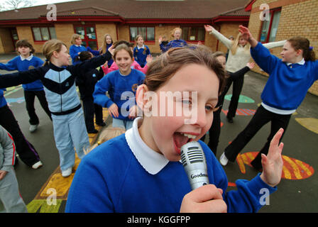 Penyrheol Primary School, Gorseinon, Swansea. Zoe Owens leads the routine with the karaeoke microphone for the lunchtime dance club. Stock Photo