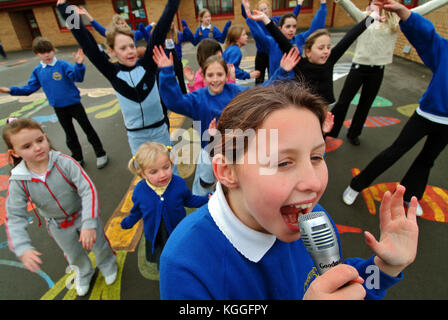 Penyrheol Primary School, Gorseinon, Swansea. Zoe Owens leads the routine with the karaeoke microphone for the lunchtime dance club. Stock Photo