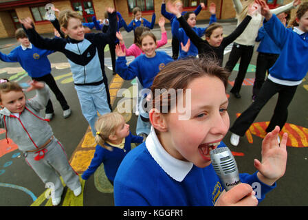 Penyrheol Primary School, Gorseinon, Swansea. Zoe Owens leads the routine with the karaeoke microphone for the lunchtime dance club. Stock Photo