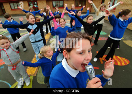 Penyrheol Primary School, Gorseinon, Swansea. Zoe Owens leads the routine with the karaeoke microphone for the lunchtime dance club. Stock Photo