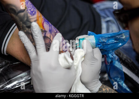 A Tattoo Artist at Work,A tattoo artist inks a designed onto the back of a local girl in his studio in Leeds. Stock Photo