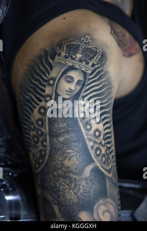 A Tattoo Artist at Work,A tattoo artist inks a designed onto the back of a local girl in his studio in Leeds. Stock Photo