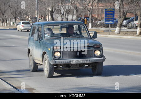 Russian ex-soviet car lada niva, unbreakable. easy to fix. Pic taken in Kazakhstan. Kazakh people. couple driving. Stock Photo