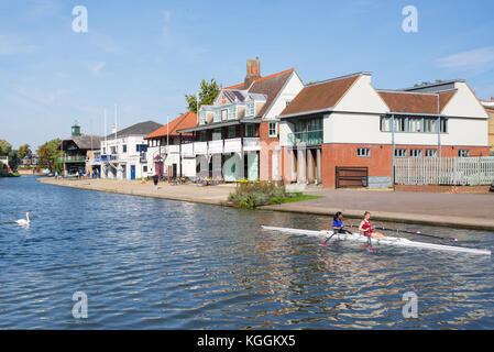 Two women students rowing on the River Cam in front of Goldie Boathouse CUBC rowing club near Midsummer Common, Cambridge England, Uk Stock Photo