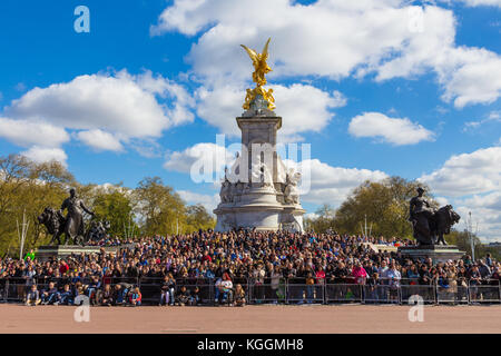 London, England - 10 April 2017 - Tourists from all over the world wait arond the base of Victoria Memorial statue to see the Buckingham Palace guards Stock Photo