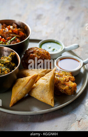 Selection of Indian dishes: samosas, onion bhaji, manchurian balls and okra Stock Photo