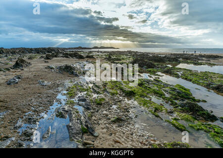 Sun beams on the horizon at the Town beach, Rhosneigr on Anglesey Stock Photo
