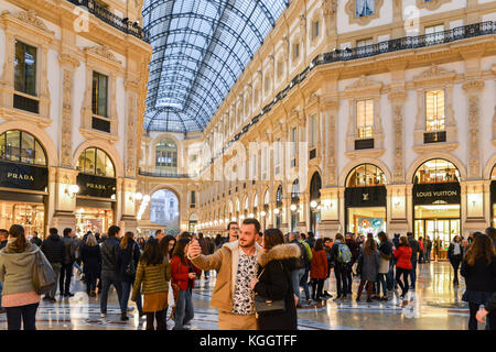 An attractive couple take a selfie picture with a smartphone at Milan's iconic Vittorio Emanuele II gallery Stock Photo