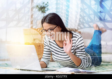 Happy young woman smiling while having a video call Stock Photo
