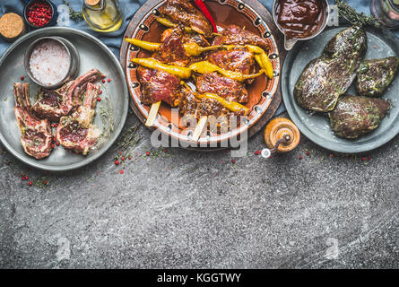 Various marinated meat in bowls for barbecue grilling or frying with spices on rustic background ,  kinds of meat, top view Stock Photo