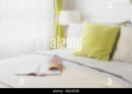 blur of modern bedroom with green pillow on bed for background Stock Photo