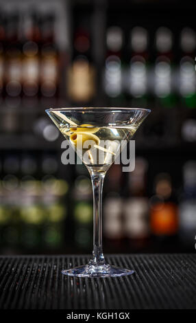 Martini cocktail with green olives on a bar counter Stock Photo