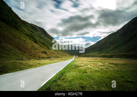 Straight mountain road leading through dramatic valley, Norway. Stock Photo