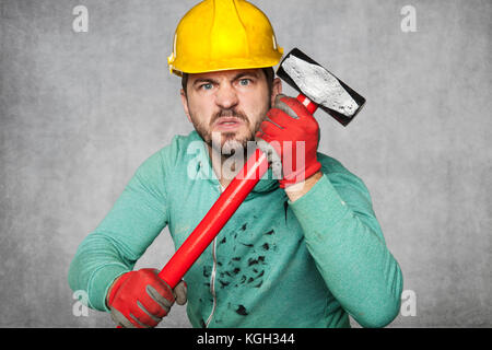 a hammer in the hands of a worker Stock Photo