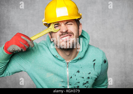 A smiling worker puts a key to the eye Stock Photo
