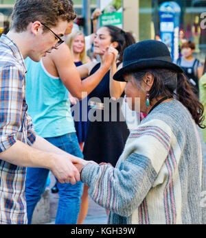 A young man dancing with an elderly native American woman in native dress. Stock Photo