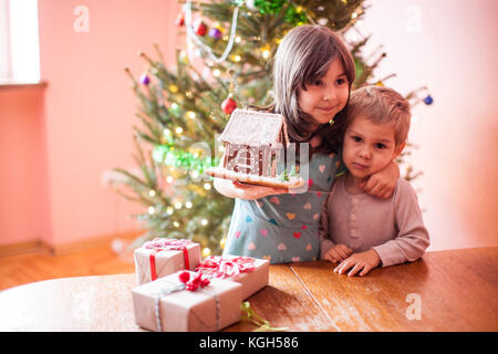 Kids with gingerbread house Stock Photo