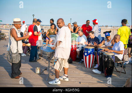 NEW YORK CITY - AUGUST 20, 2017: View of Puerto Rican's playing drums enjoying a summer's day on crowded Coney Island boardwalk.
