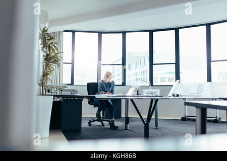Female architect working on construction blueprint. Businesswoman working on new building plan. Stock Photo