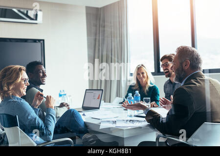 Business people having casual discussion during meeting in board room. Group of businesspeople working together. Stock Photo