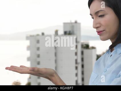 Digital composite of Businesswoman with hand palm open in city Stock Photo