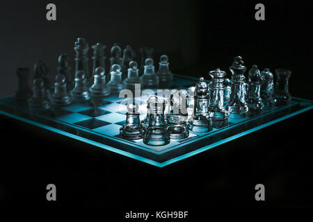 Close up view of a corner of glass transparent chess board with chess pieces on black background Stock Photo