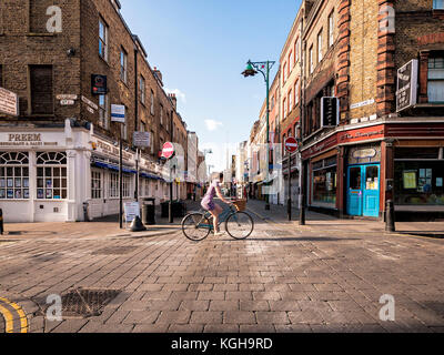Bicycle crossing Hanbury Street and Brick Lane early on a sunny summer morning on the way towards the City of London Stock Photo