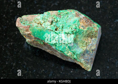 macro shooting of natural mineral rock specimen - rough Garnierite (nickel ore) stone on dark granite background from Verkhny Ufaley district, Ural, R Stock Photo