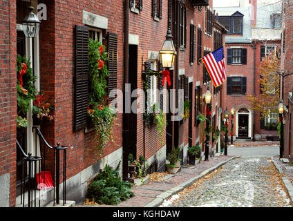 Historic Acorn Street in Beacon Hill, Boston. Christmas decorations, historic American flag, cobblestone pavers, street lamps. Stock Photo