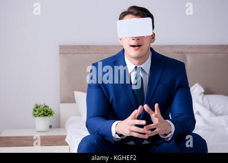 Businessman wearing a virtual reality headset in the bedroom Stock Photo