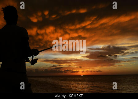 Fishing during a dramatic sunset in Havana, Cuba. Stock Photo