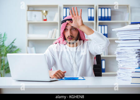 Arab businessman working in the office doing paperwork with a pile of papers Stock Photo
