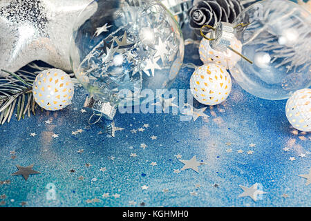 blue glitter background with sparkling confetti and different christmas tree decorations macro view Stock Photo