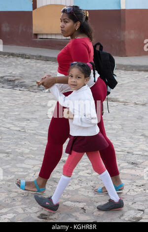 Cuban mother and daughter walking to school , Trinidad Cuba Stock Photo