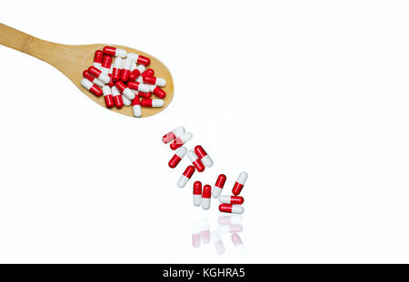 Colorful of antibiotics capsule pills in wooden spoon are spilling isolated on white background with copy space and clipping path. Antibiotic drug use Stock Photo